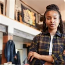 Kvinna står i klädbutik.