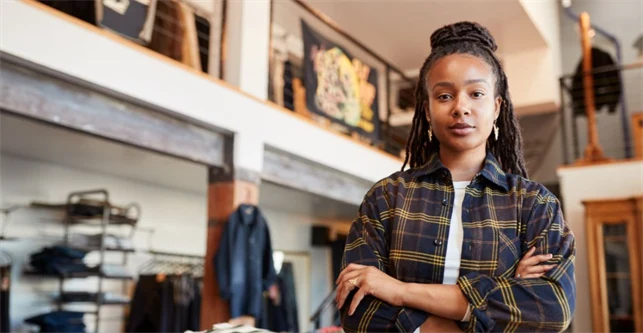 Kvinna står i klädbutik.